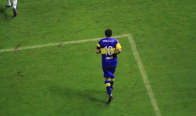 Juan Román Riquelme im Gelb-blauen Trikot der Boca Juniors Buenos Aires trabt aus dem Strafraum. Sein Trikot schmückt sein Vorname Román und die Rückennummer 10.